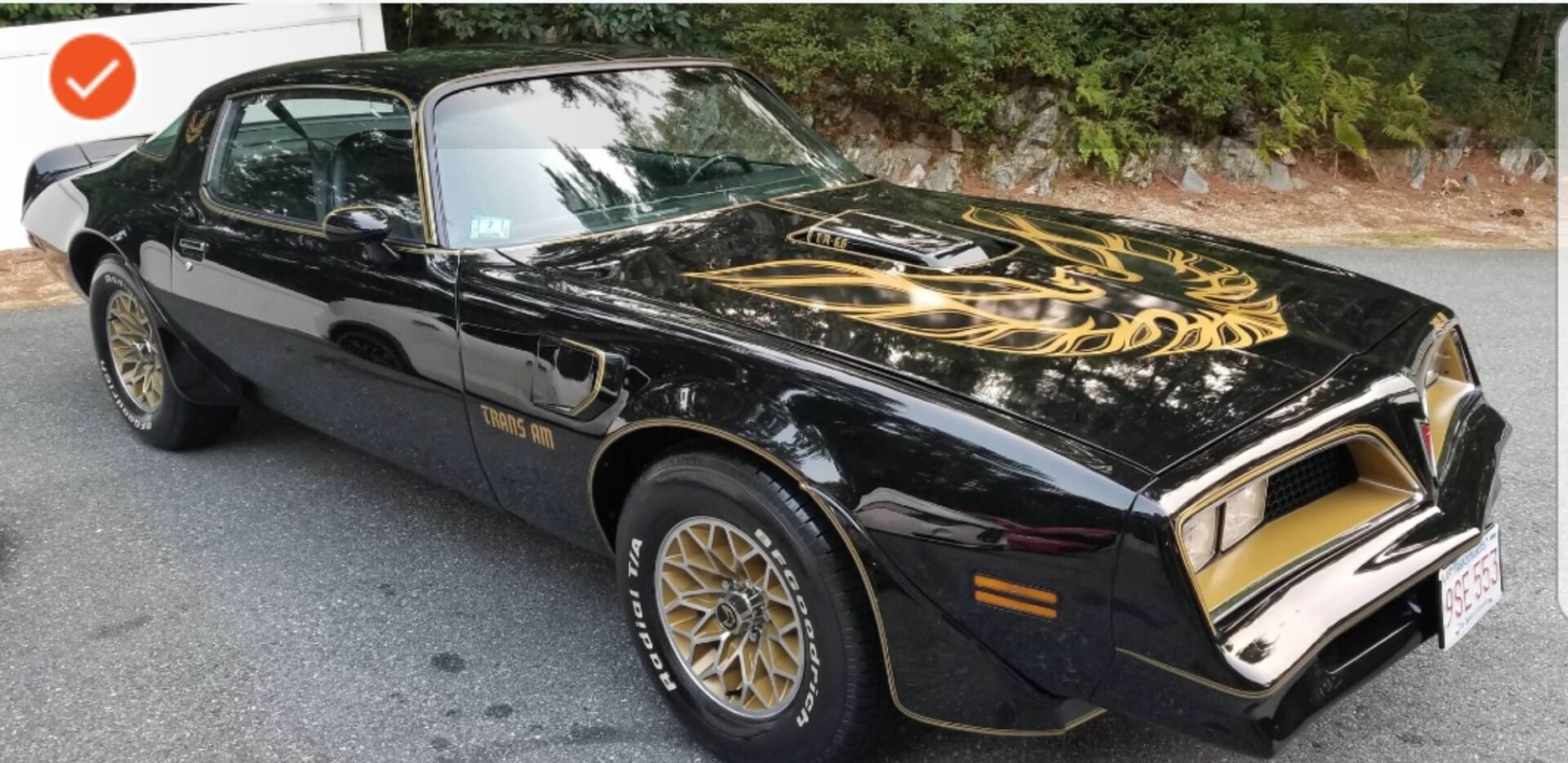A black and gold car parked on the side of the road.