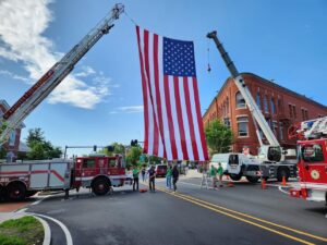 A group of people standing next to an american flag.